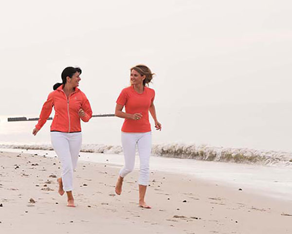 2 Frauen laufen am Strand
